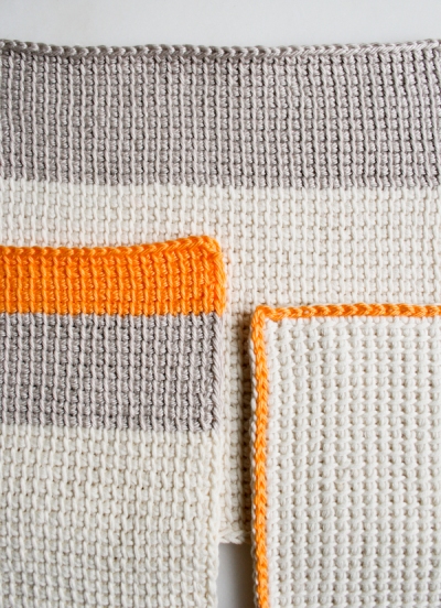 Tunisian crochet washcloths in orange and grey yarn by the Purl Bee